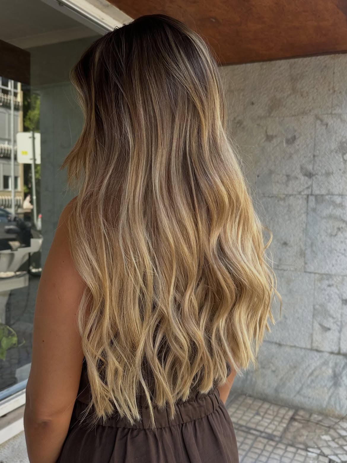 Cabelo comprido loiro, ondulado e com brilho, visto de trás